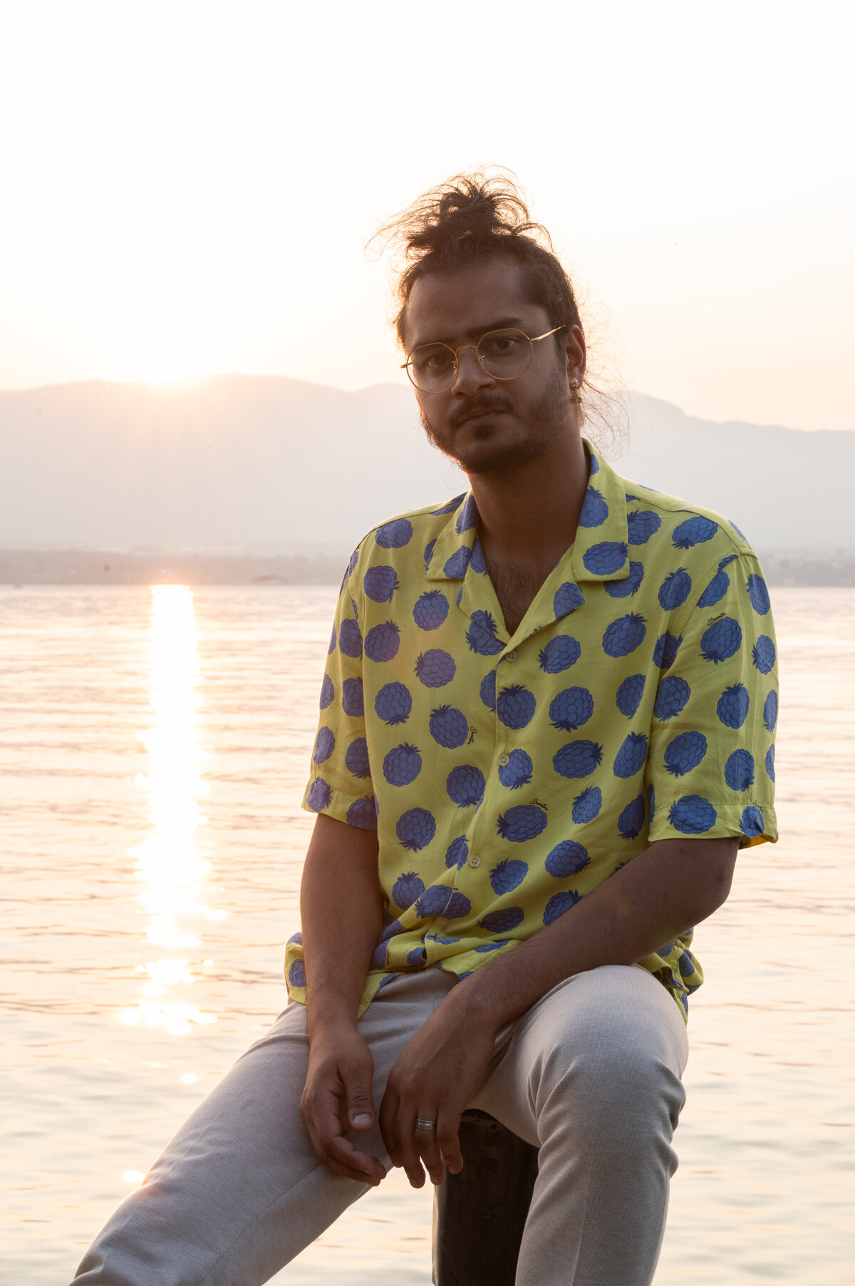 Portrait of Ravi Ramsahye at dusk on a lakeside pier, backlit by the setting sun