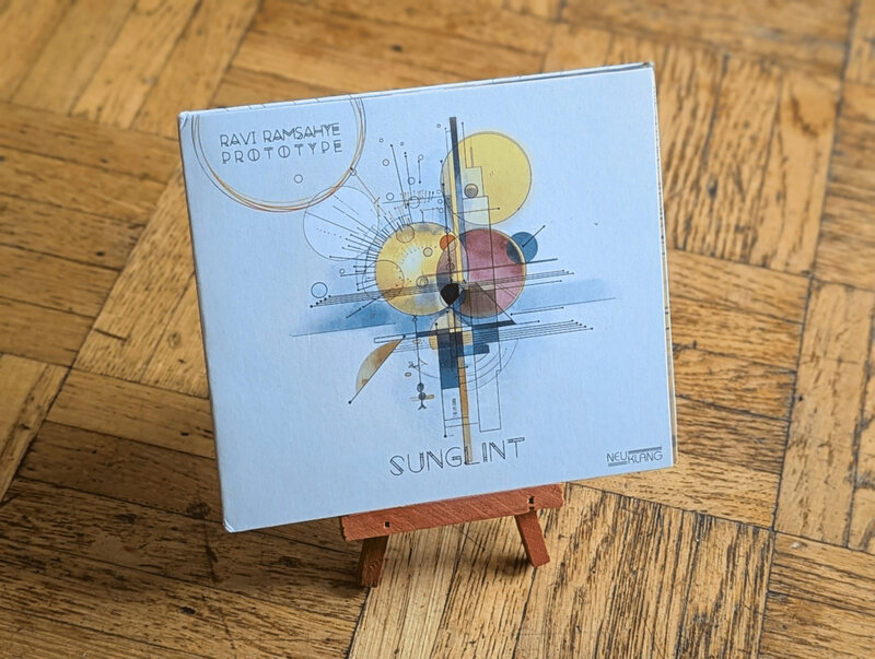 Sunglint 6-panel digipack CD standing on a small wooden easel